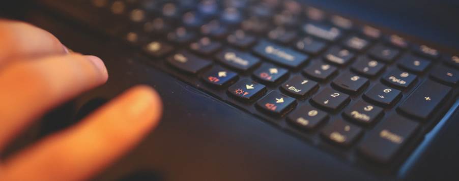 A finger pointing at a keyboard

Description automatically generated