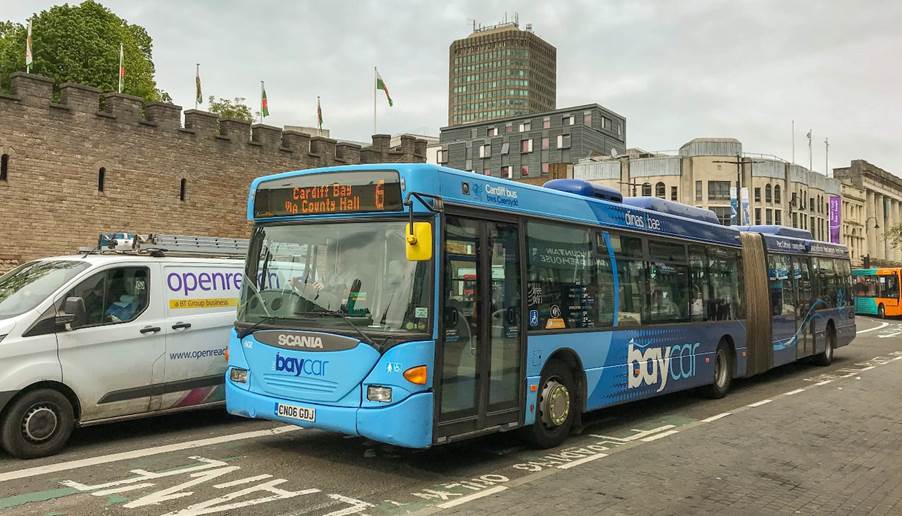 A blue bus on the street

Description automatically generated