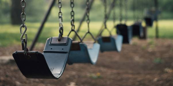A group of swings in a park
Description automatically generated