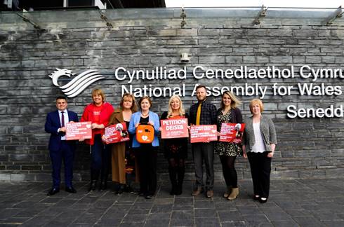 A group of people standing in front of a building

Description automatically generated